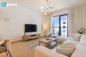 a living room with white furniture and a flat screen tv at HiGuest - Stylish 1BR Apartment in La Mer in Dubai