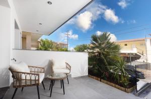 a balcony with two chairs and a table at Victory VIP apartments in Kallithea Halkidikis