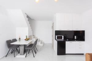 a kitchen with a table and chairs and a microwave at Victory VIP apartments in Kallithea Halkidikis