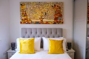 Un dormitorio con una cama con almohadas amarillas y una pintura en Stunning 3 Bed Home in Somerset with 2 Parking Spaces, en Haybridge