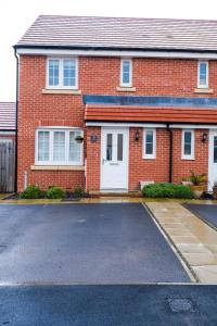 una casa de ladrillo rojo con garaje blanco en Stunning 3 Bed Home in Somerset with 2 Parking Spaces, en Haybridge