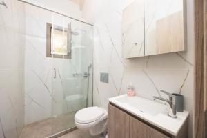 a bathroom with a toilet and a sink and a shower at Villa Angela in Trapezaki +10 photos