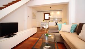 un soggiorno con un divano e una televisione di Missio Triplex house in Old Town of Palma a Palma de Mallorca
