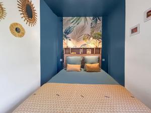 una camera da letto con un letto con una parete blu di Les teinturiers I Charme et Calme à Avignon ad Avignone