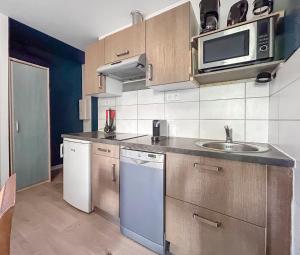 una cucina con lavello e microonde di Les teinturiers I Charme et Calme à Avignon ad Avignone