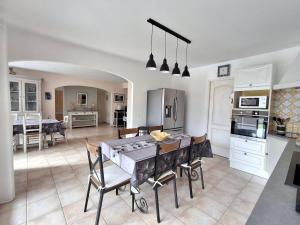 Una cocina y un comedor con mesa y sillas. en La Bastide de Laura, en LʼIsle-sur-la-Sorgue