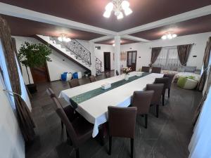 a large dining room with a long table and chairs at Pensiunea Mihade in Vama Buzăului