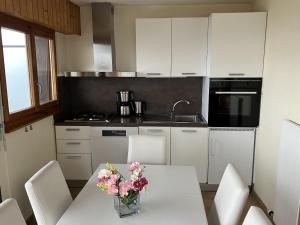 a kitchen with a table with a vase of flowers on it at Diablerets D 023 - MOUNTAIN apartment 6 pers in Veysonnaz