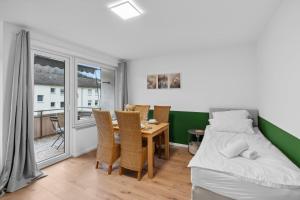 a bedroom with a bed and a table and chairs at Geschäftsreisetraum 2SZ 5P - Balkon, Waschtrockner in Oberkochen