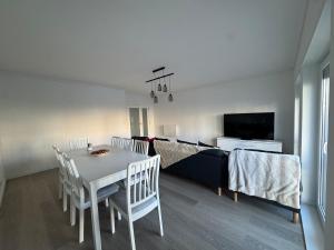 a living room with a table and chairs and a tv at Vagueira Apartment in Praia da Vagueira