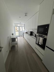 a kitchen with white cabinets and a stove at Vagueira Apartment in Praia da Vagueira