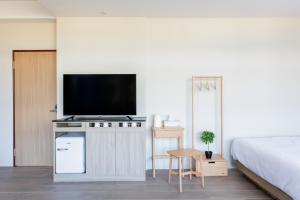 a bedroom with a bed and a flat screen tv at Richen Shanshan in Chün-hsin