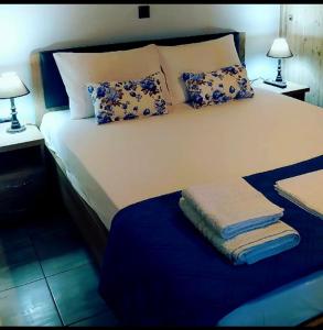 a bedroom with a large bed with pillows and two lamps at Olivo Apartment - Studio in Lixouri