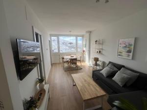 salon z kanapą i stołem w obiekcie IMEDA Apartamentos MONTE GORBEA w mieście Sierra Nevada