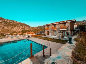 a villa with a swimming pool and a mountain at Alice Tatil Evi OTEL in Selimiye