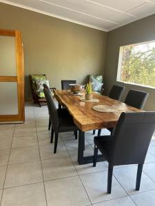 a dining room with a wooden table and chairs at Maroela 1022 in Marloth Park