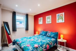 una camera da letto con un letto e una parete rossa di Dalmarnock Stay a Glasgow
