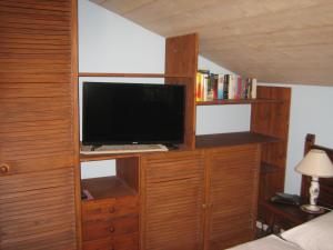 a bedroom with a tv on a wooden wall at Haus Osterried in Schwangau