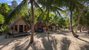 a house on the beach with palm trees at Or Mandira Homestay in Fam