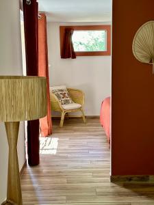 a living room with a chair and a window at Hôtel Palombaggia in Porto-Vecchio