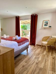 a bedroom with a bed and a window at Hôtel Palombaggia in Porto-Vecchio