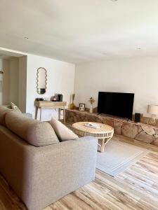 a living room with a couch and a table at Hôtel Palombaggia in Porto-Vecchio