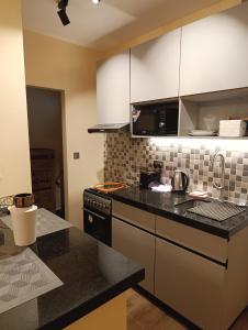 a kitchen with black counter tops and a stove top oven at Unity 1 in Tatu City +2 photos