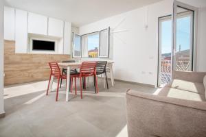 a living room with a table and chairs and a couch at Aquarius Deluxe Apartments in Santa Teresa Gallura