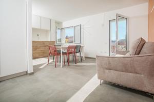 a living room with a table and chairs and a couch at Aquarius Deluxe Apartments in Santa Teresa Gallura