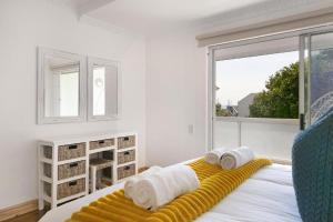 a bedroom with a bed with towels on it at Gordonia 10 in Cape Town