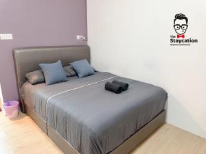 クチンにあるStaycation Homestay 64 Gem Suiteのグレーのベッドバイザー付きのベッドルームのベッド1台