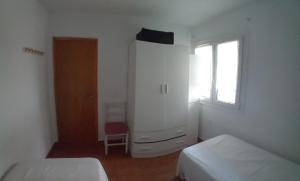 una camera da letto con due letti, un comò e una finestra di Eki a Conil de la Frontera Altre 8 foto