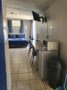 a small room with a bed and a table with a microwave at Inn-Finity Empire in Witfield