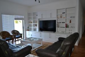 a living room with a couch and a flat screen tv at 9 Kiaat Suites in Klerksdorp