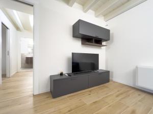a living room with a flat screen tv on a wall at Bright apartment with terrace and pool in Milan