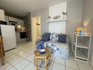 een woonkamer met een bank en een tafel bij Appt 2 pièces CHATELAILLON PLAGE - CL040-H11 in Châtelaillon-Plage