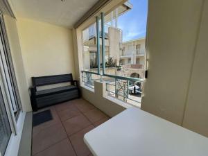 een kamer met een balkon met een bank en een raam bij Appt 2 pièces CHATELAILLON PLAGE - CL040-H11 in Châtelaillon-Plage