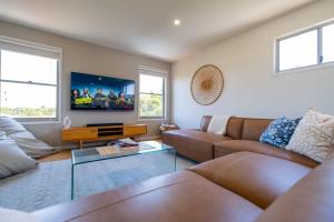 a living room with a couch and a tv at Chic Coastal Home on Orealla in Sunrise Beach