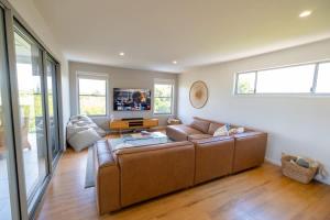 a living room with a couch and a tv at Chic Coastal Home on Orealla in Sunrise Beach