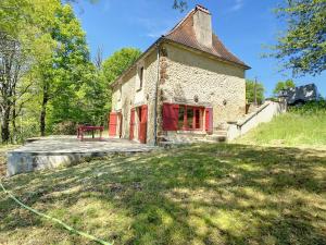 an old building with red doors and a bench in front at Au coeur de la Dordogne, maison pour 6, piscine in La Pinsonnie
