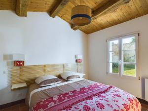 a bedroom with a large bed with a wooden headboard at 400m de la mer, belle résidence pour 8 avec jardin in LʼHerbaudière