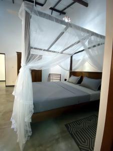 un dormitorio con una cama con dosel en Dana Villa, en Bentota