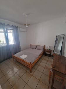 ein Schlafzimmer mit einem Bett in der Zimmerecke in der Unterkunft Beach front apartment Psili Ammos in Psili Ammos