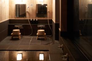 a bathroom with two toilets and two mirrors at RICKA Katsuura in Katsuura