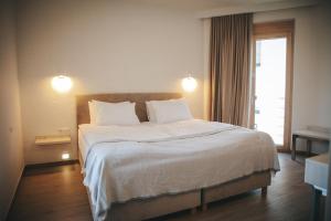 a bedroom with a large bed with white sheets and a window at Hotel Plein Air Residence & Resort in Vatra +103 photos