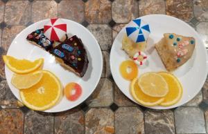 two plates of food with orange slices and cake at Jacuzzi Balnéo piscine "La Palmeraie Oasis" in Férolles