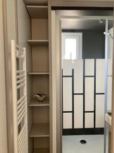 ein begehbarer Kleiderschrank mit Glastür in der Unterkunft Mobil Home piscine chauffée Pont l 'Abbe in Pont-lʼAbbé