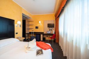 una camera d'albergo con un letto e una scrivania di Hotel Majorana a Rende