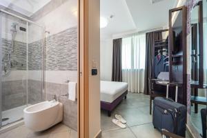 una camera d'albergo con bagno dotato di lavandino e doccia di Hotel Majorana a Rende