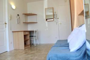 een slaapkamer met een blauw bed, een bureau en een tafel bij Appt 2 pièces LA ROCHELLE - LR010-022 in La Rochelle +8 foto's